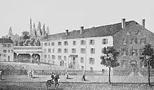 Sketch of a street scene with people walking on a sidewalk in front of a wrought iron fence. Parallel and behind the fence is a small building to the left connected to an open-front shed across the back and down the right side a large, stone, 4-story building.