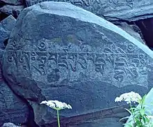 Om mani padme hum -variation of the six syllable mantra of Avalokiteshvara. is inscribed in Tibetan script on this rock behind the main building.