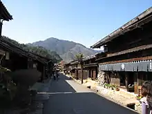 Small street lined by wooden two-storeyed houses.