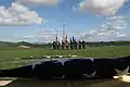 A joint-force color guard stands before the grave sites. These first five burials marked the official opening of the new facility.