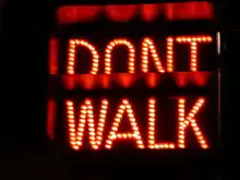 A signal displaying in red the text DON'T WALK