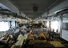 Supply and deck department Sailors transfer cargo in the hangar bay of the aircraft carrier USS George Washington during a replenishment at sea, 2009.