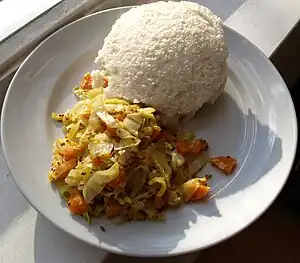 Ugali (top), also known as pap, with cooked cabbage and vegetables