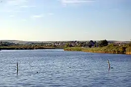 A lake with houses beyond