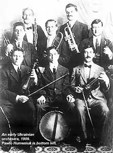 Black and white picture of an orchestra of eight men with various instruments