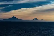 Shishaldin, Isanotski and Roundtop volcanoes as seen from the Unimak Pass in morning light.