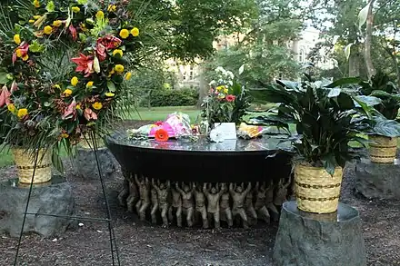 The Unsung Founders Memorial by a wreath and bouquets of flowers in 2018