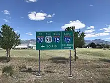 Signage at the T-intersection in Holden. This is the northern end of SR64, but the BGS simply points the way to Interstate 15 (May 2020)