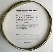 V3Ga superconducting tape (10×0.14 mm cross section). A vanadium core is covered with 15 µm V3Ga layer, then 20 µm bronze (stabilizing layer) and 15 µm insulating layer. Critical current 180 A (19.2 tesla, 4.2 K), critical current density 20 kA/cm2