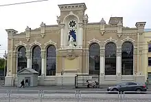 Historical building of VEF featuring a statue of Zeus holding a thunderbolt in the middle