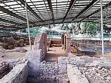 The ruined walls of the villa are covered by a roof to protect them from the elements.