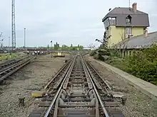 Image 20The "hump" of a hump yard. Railcars travel past retarders, which control their speed, and are directed onto tracks to be assembled into new trains. The control tower operates the retarders. (from Rail yard)