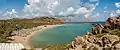 Panorama of Vai beach from the southern headland showing the roof of the restaurant, the sun shelters, the northern headland and pigeon rocks.