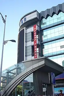 A vertical, red banner hanging high on a building with Chinese writing: "维护法律尊严，严惩犯罪分子"