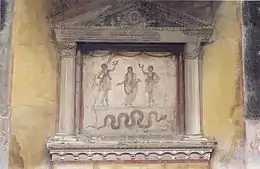 Ancestral genius (upper centre) flanked by Lares, with serpent below. Lararium, House of the Vettii Pompeii