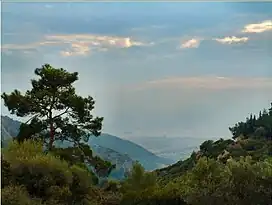 A port city unravels since millennia in the outlying waters of the Gulf of İzmir as narrow as a strait in its end as seen here from Mount Yamanlar. Mount Yamanlar is also where a crater lake named Karagöl (meaning Black Lake in Turkish) and also called as "Lake Tantalus" is found.