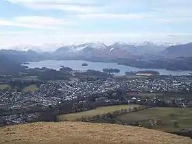 View of lake surrounded by mountains, seen from a mountain peak