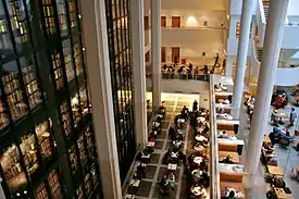 View looking down on several people working at desks; the King's Library is seen on the left