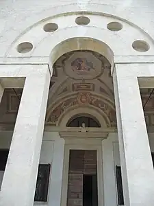 The serliana of the atrium, with the family's coat of arms and military trophies.