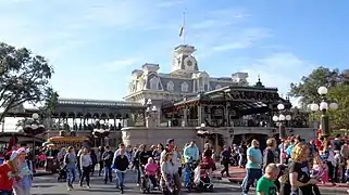 An old-fashioned railroad station building with a flagpole on its roof