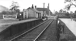 Small wooden railway station with a single rail track