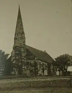 Black and white photograph of the church of St John, the steeple prominent against the sky