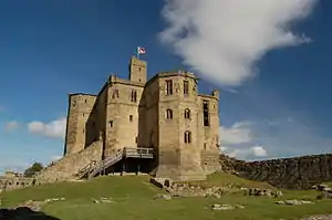 A tall tower stands above the ruined castle. A wooden staircase leads into the tower, its windows are empty. The facing is smooth ashlar, and on top is a smaller square look-out tower on which stands a flagpole.