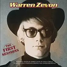 A photo of Zevon looking to the camera, wearing a hat, sunglasses, a turtleneck, and a vest