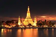 Image 44Wat Arun, the most prominent temple of the Thonburi period, derives its name from the Hindu god Aruṇa. Its main prang was constructed later in the Rattanakosin period. (from History of Thailand)