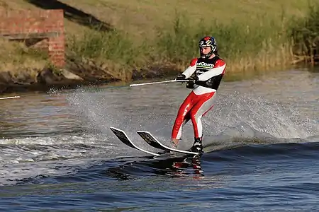 Image 1WaterskiingPhoto: Fir0002A man engaged in waterskiing, a sport in which an individual is pulled behind a boat or a cable ski installation on a body of water, skimming the surface. Waterskiing is a relatively young sport, having been invented in the early 20th century. The skis this person is wearing are specialized for ski jumping.More selected pictures