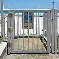 Beachside gate with a self-latching device and a higher than 54” release mechanism.