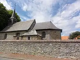 Photo of a small stone church under a blue sky with white clouds.