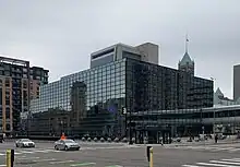 A color photograph of a blue mirror facade of an office building.