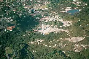 Aerial view of Whakarewarewa; Pohutu Geyser is erupting.