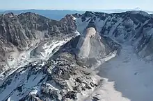 February 2005: The Crater Glacier nearly split at its south end by the new lava domes. Overthickening and compression of the eastern glacier arm is apparent.