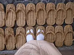 More finely-woven zori (the thong is also further back). Sewn-on outsoles are just visible at the edges.