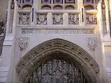 An arched stone doorway with five carved seals above it.