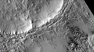 Short dark streaks are dark fans caused by outgassing of carbon dioxide and dark material. Layers are easily visible in the wall of the crater.  Note: this is an enlargement of the previous image of McMurdo.  Picture taken with CTX camera (on Mars Reconnaissance Orbiter).