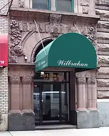 The entrance to the Wilbraham on 30th Street. There is a green awning above the entrance; the building's name is misspelled on the awning.