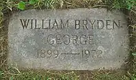 Flat grey granite marker engraved with George's name, birth year and death year