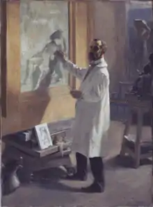 A man wearing a white smock working on a painting