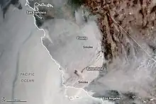 A satellite picture of California's lower half shows thick brown smoke covering the lower Central Valley and much of Southern California