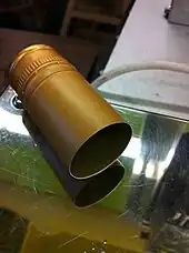 A capsule is fitted onto a wine bottle and heat shrunk tightly