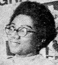 An African-American woman with a short natural hairdo and round glasses.