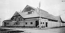 Exterior of wooden building with a peaked roof and arched windows