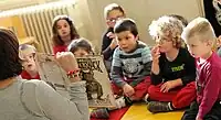 Woman_reading_picture_book_to_children