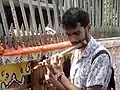 A student playing flute in front of the institute building