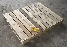 A wooden pallet with a glove on it