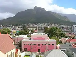 The southern part of Woodstock, seen from the northern end, with Devil's Peak in the background. The pink building in the foreground is the town hall.