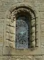 Stone window surround decorated with fossils, plants and pinecones
